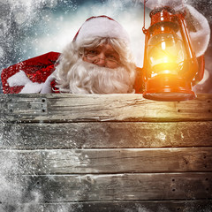 Santa Claus with lamp of light in hand and free space for your text on retro wooden billboard place 