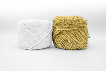 Two different colors yarn / rope balls tied placed close and attached to each other.