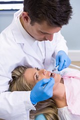 Naklejka premium Dentist examining patient at medical clinic