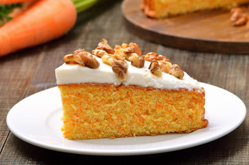 Piece of carrot cake with icing decorated walnut