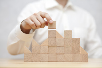 Man's hand stacking wooden blocks. Business development concept