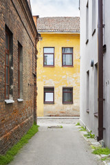 Fototapeta na wymiar Narrow alley in old town. Summertime in the city