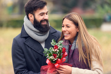 Smiling Romantic Valentines-Day Couple with Flowers in Park