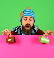 Hipster with beard and surprised face has coffee