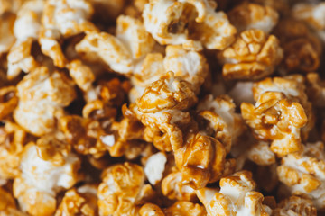 Caramel opcorn in bowl on the wooden table.