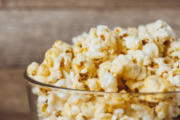 Popcorn in a bowl on the wooden table.