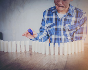 Businessmen put a hand on the dominoes