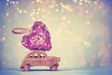 wooden toy car with pink heart from sequin on top