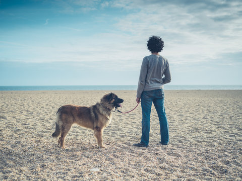 Young man with dog on the beach