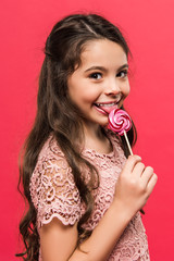 child licking colored lollipop