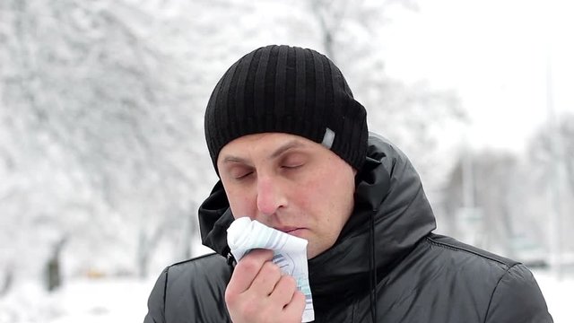 A man sick with flu or cold using a handkerchief