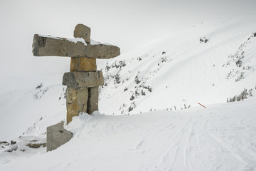Inukshuk made of stones on snow covered mountain, Whistler, British Columbia, Canada