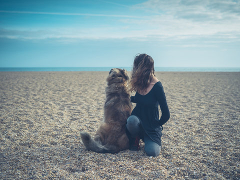 Young woman on beach with giant dog