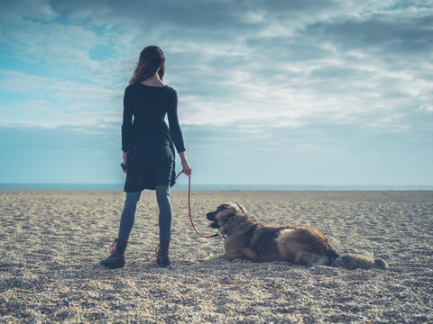 Young woman on beach with giant dog