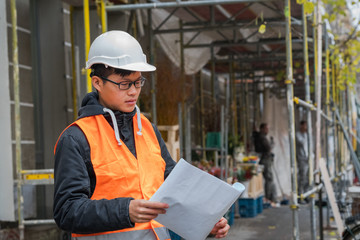 Young Asian engineer at work on construction site