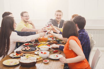 People say cheers clink glasses at festive table dinner party