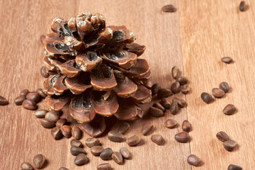 Pine nuts with cones on mahogany boards.