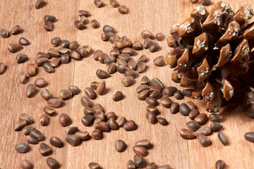 Pine nuts with cones on mahogany boards.