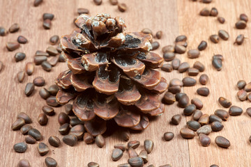Pine nuts with cones on mahogany boards.