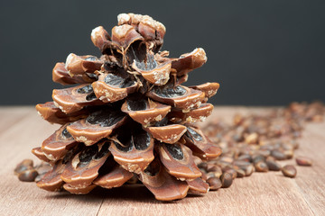 Pine nuts with cones on mahogany boards.