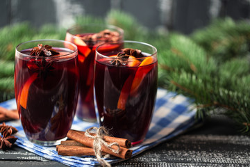 Christmas hot mulled wine in a glass with spices and citrus fruit. Mulled wine with cinnamon, anise and orange. 