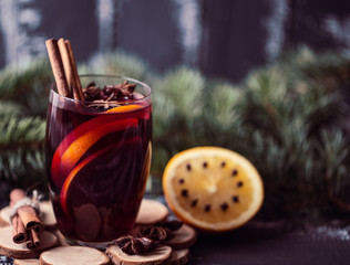 Christmas hot mulled wine in a glass with spices and citrus fruit. Mulled wine with cinnamon, anise and orange. 