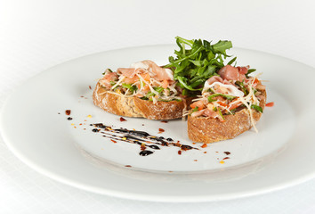 Bruschetta with tomatoes, prociutto ham and rucola