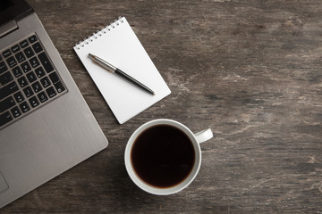 Top view of notebook, notepad, pen and coffee. Business still life on old wooden table