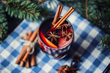 Christmas hot mulled wine in a glass with spices and citrus fruit. Mulled wine with cinnamon, anise...