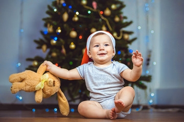 Portrait of a happy child with toy near a Christmas tree