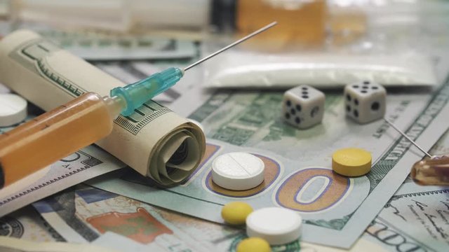 Pills, drugs, cocaine, syringe on dollar bank notes 