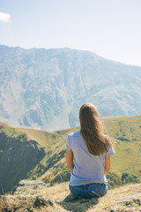 Naklejka premium Hiker with backpack Hiking on the top of the mountain a Young Woman, a Girl. A Healthy Active Lifestyle. Adventure in nature.
