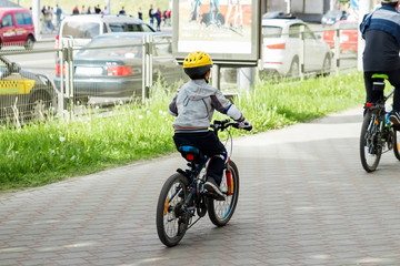 Fototapeta na wymiar The man with the kids on a bike ride around the city. Spain. San Sebastian. June, 2014/A man with his children on a walk