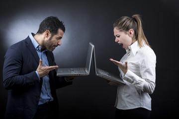 un uomo al computer scrive ad una ragazza che legge divertita (non si guardano anche se sono...