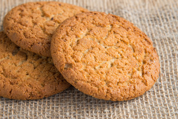 Stack of freshly baked oat biscuits on the background of burlap