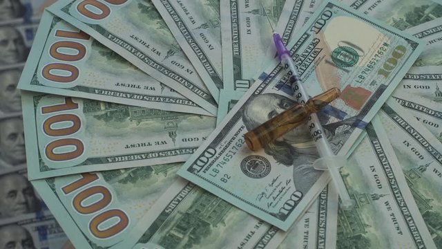 Drugs and pills for addiction lie on the thousands of paper dollars 