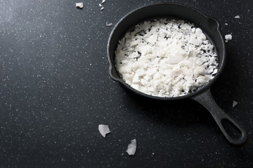 Fresh coconut flakes or white chocolate chip isolated on dark background with copy space 