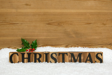 Wooden Christmas Word with holly and snow