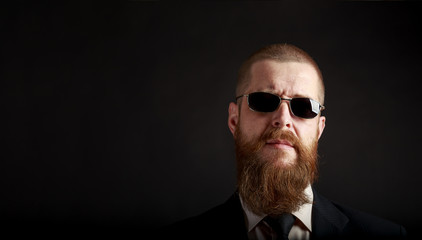 closeup portrait of a bearded businessman in black glasses with place for copy-paste