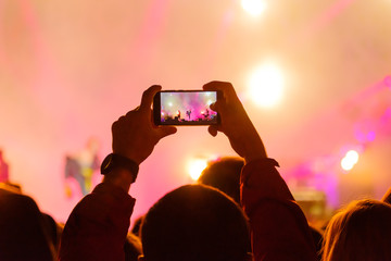 Fototapeta na wymiar Concert visitor shoots video on a smartphone