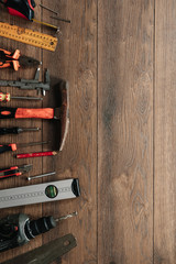 A construction tool on a brown wooden background. View from above. Picture background, screensaver. The concept of construction, repair, construction, production, design. Copy space.