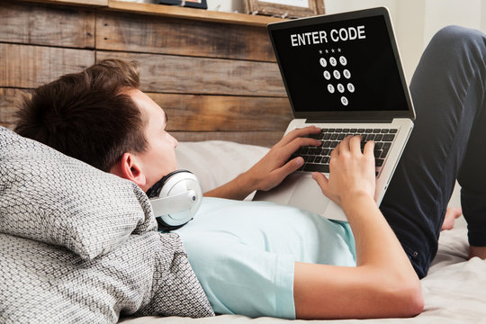 Man entering code in a laptop to get access to a private system while rest at home.