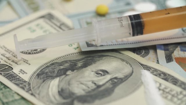 Pills, drugs, cocaine, syringe on dollar bank notes 