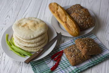 bread, baguette and chili on a wooden table