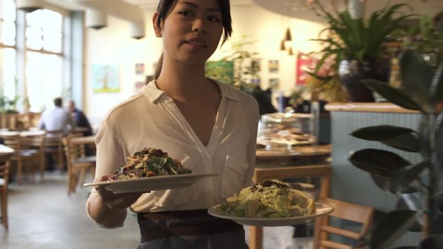 Tracking shot of a waitress serving food