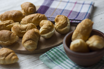 Fresh homemade croissants on white wooden table