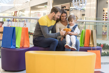 Happy family with child doing shopping together in the shopping mall