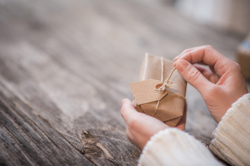 Female hands opening handmade gift box for Christmas or New Year