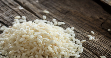 Heap of raw rice on an old wooden surface