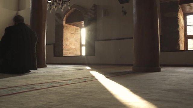  Single Muslim Man is Sitting and Praying in Historical Mosque on Sunny Day with Glow Stock video 